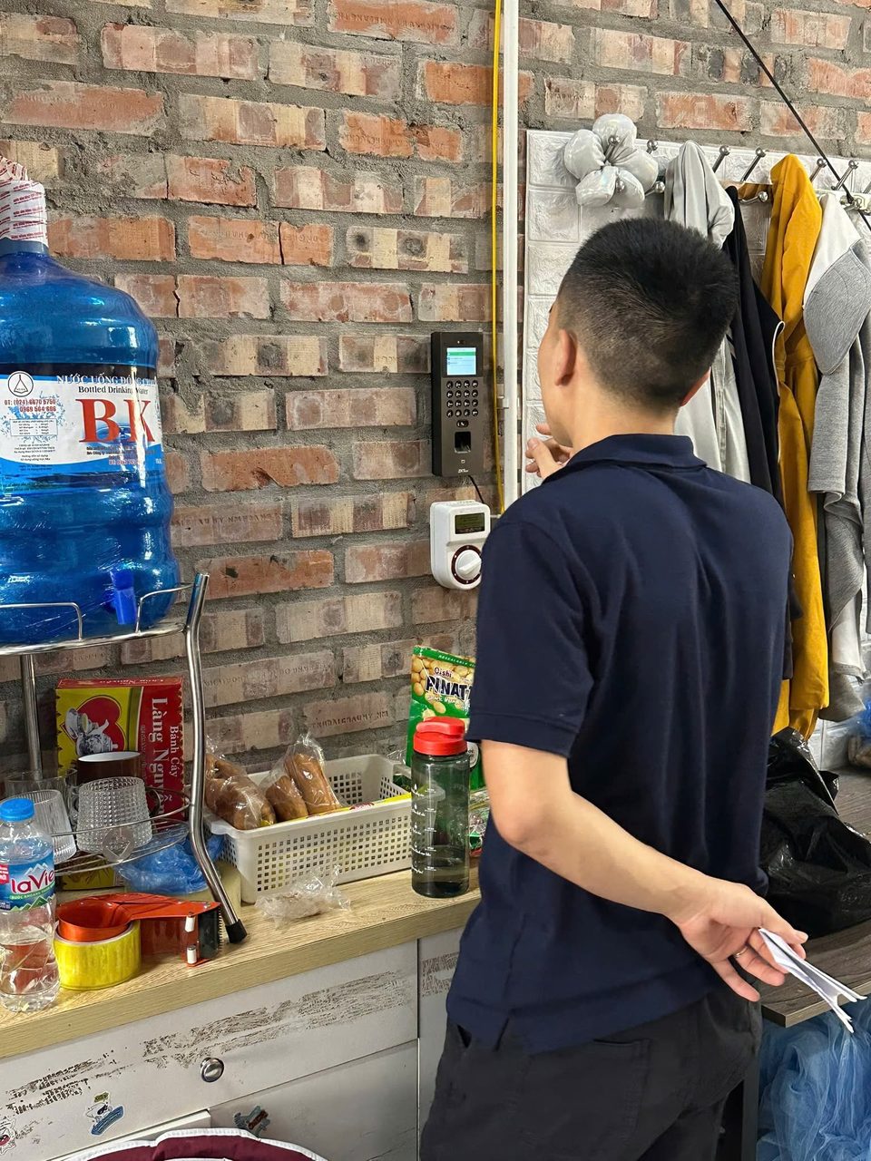 Nh&acirc;n vi&ecirc;n chấm c&ocirc;ng v&acirc;n tay ở khu ph&iacute;a sau cửa h&agrave;ng b&aacute;n lẻ